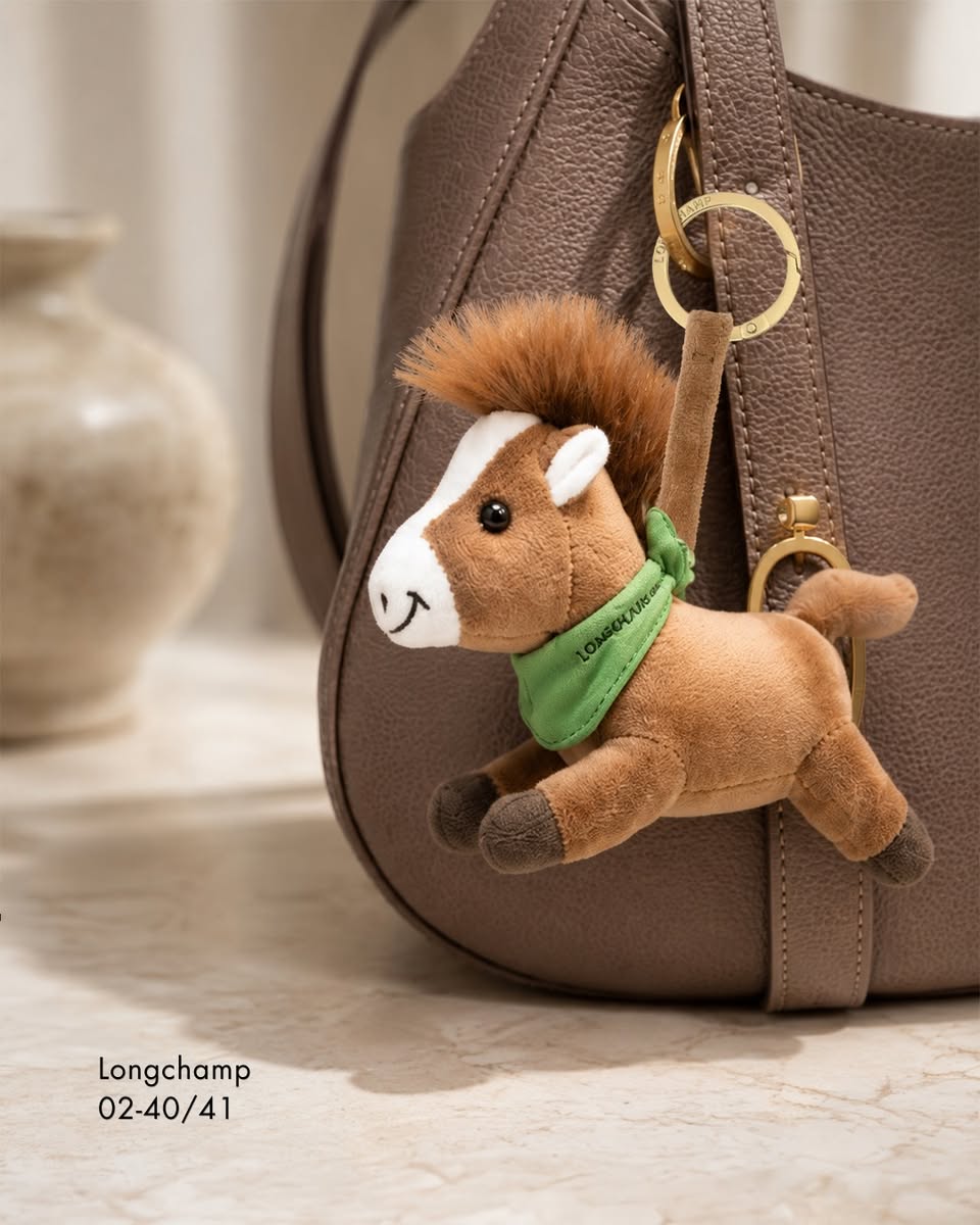 Longchamp plush horse keychain on brown handbag at Paragon