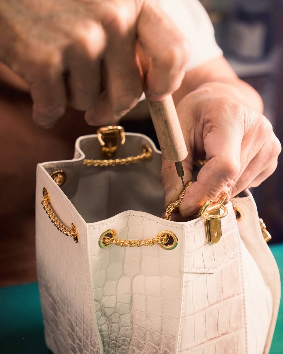 White crocodile leather bucket bag being assembled by craftsman