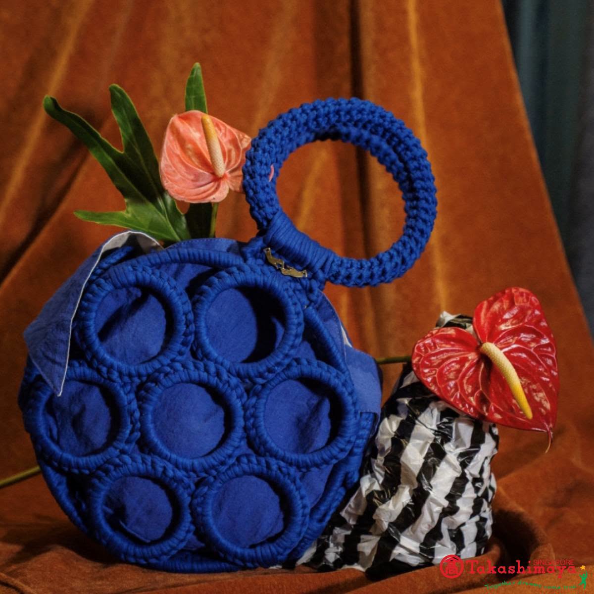 Blue crocheted handbag with floral accents from Webeings
