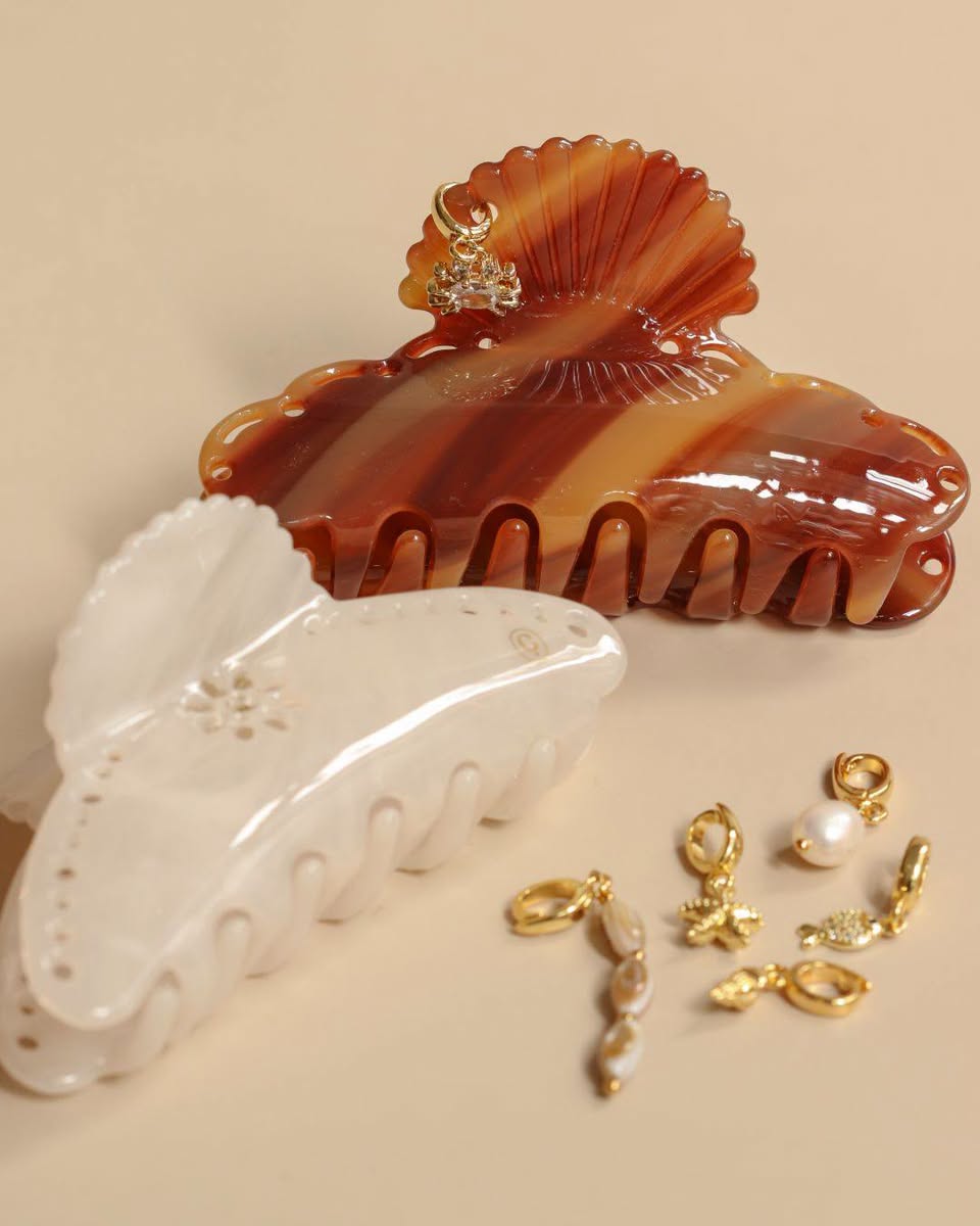Decorative hair clips with gold-toned charms including pearl and flower details