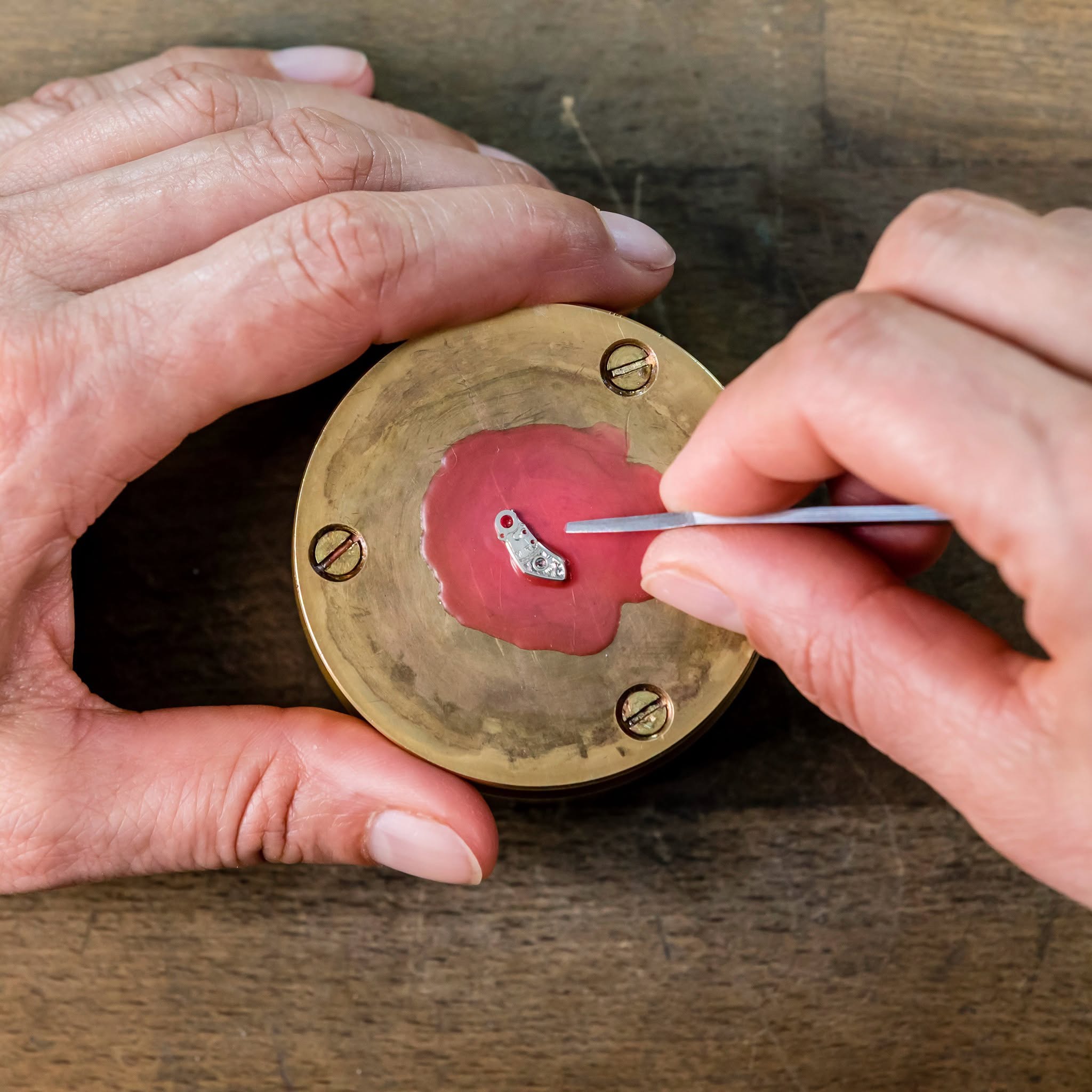 Master engraver working on a small metallic watch component