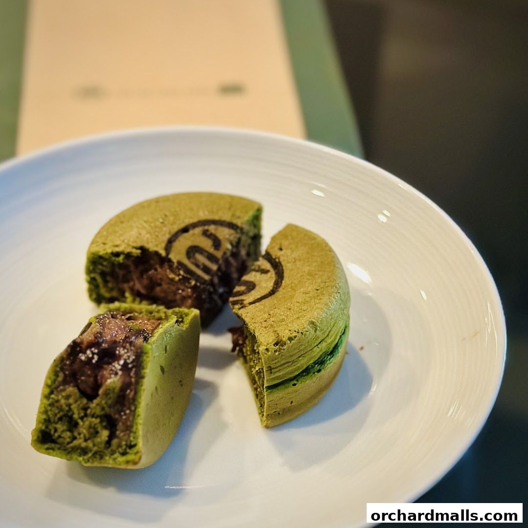 A matcha dessert with red bean filling, presented on a white plate.