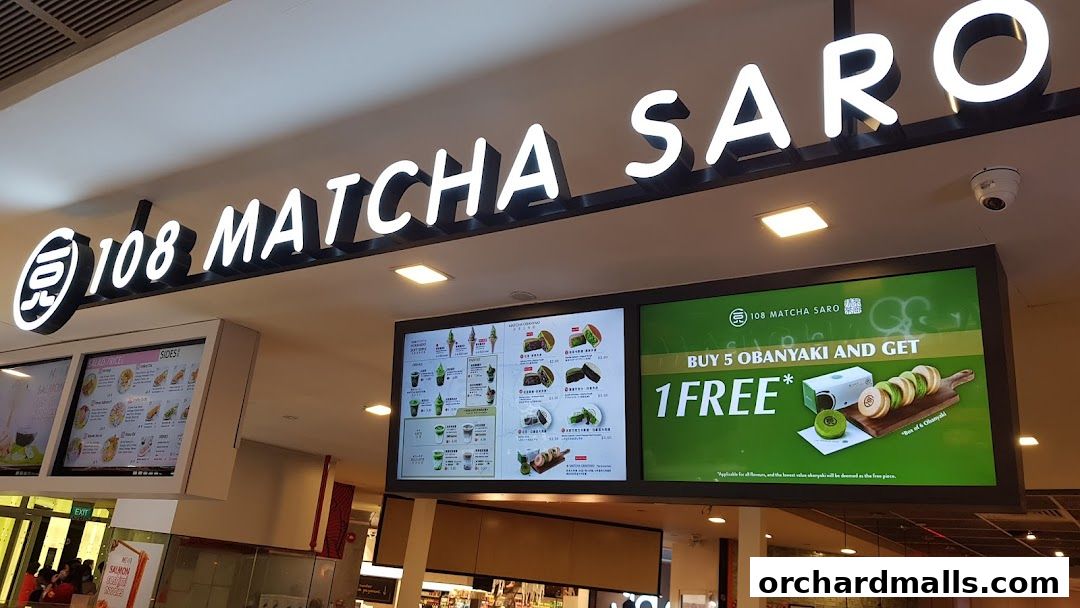 The illuminated sign for 108 Matcha Saro above digital menu boards displaying matcha treats and a special offer.