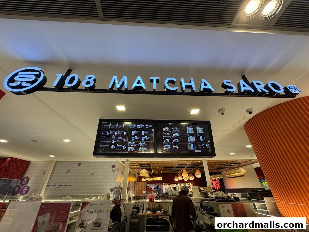 The illuminated sign for '108 Matcha Saro' above a digital menu board and shop interior.
