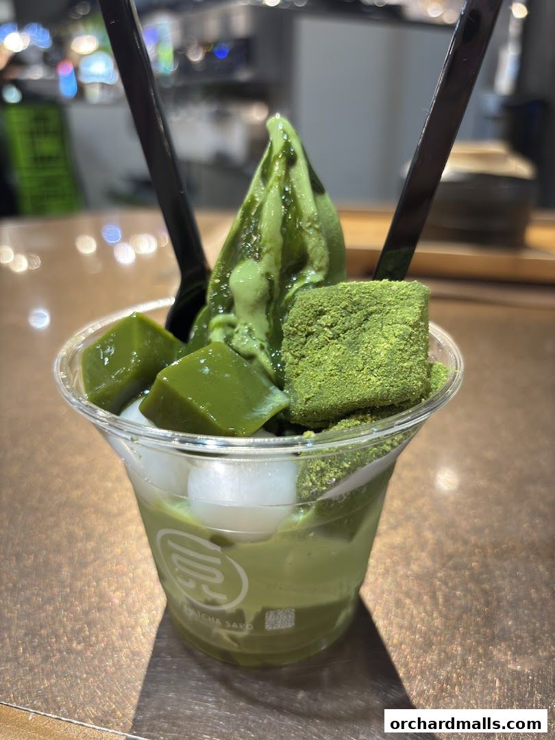 A delicious matcha dessert in a clear cup with jelly, mochi, and matcha powder.