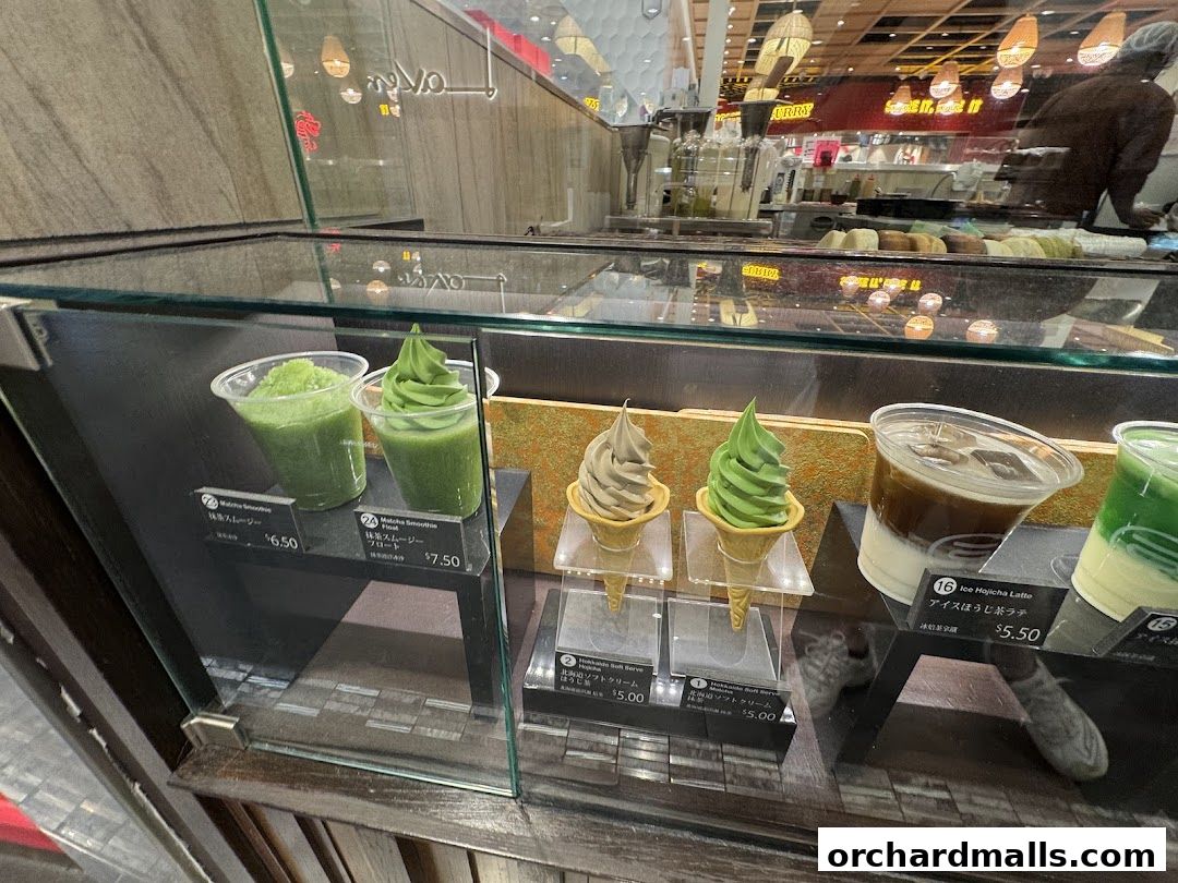 A display case showcasing various matcha-flavored drinks and soft-serve ice cream.