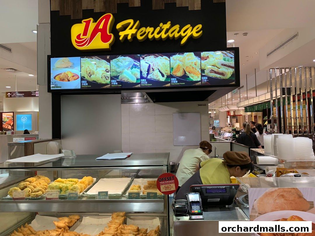 A food stall with a display of fried snacks and a menu board above.