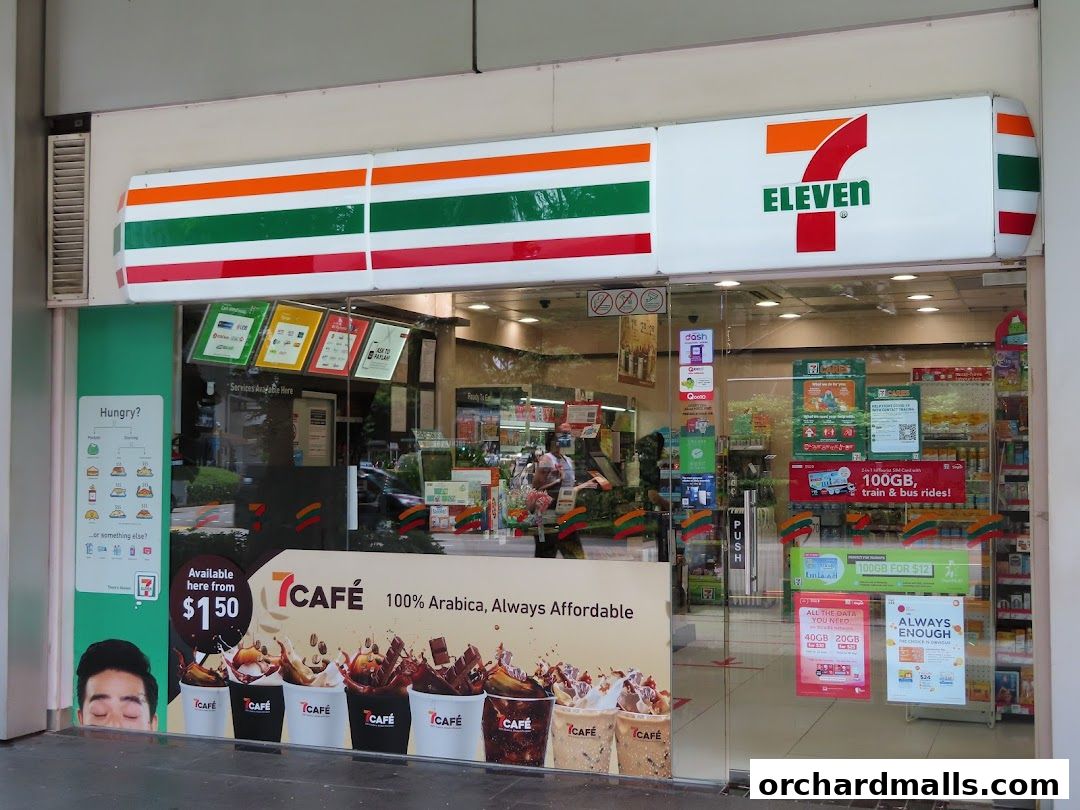 The exterior of a 7-Eleven convenience store with promotional posters and the store's logo.