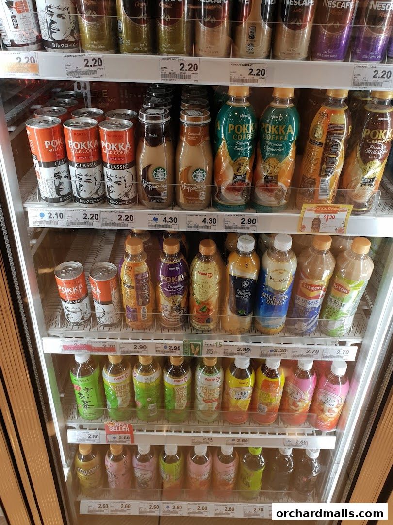 A refrigerated display case filled with various beverages, including coffee drinks, teas, and juices.
