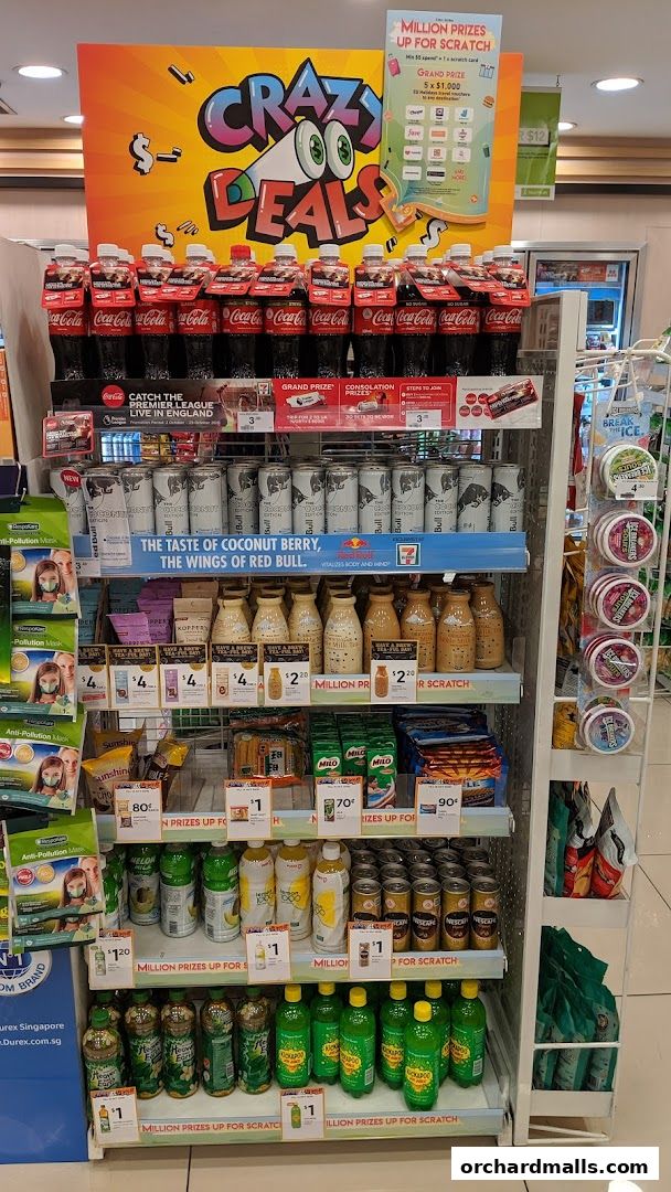 A 7-Eleven store display featuring Coca-Cola, Red Bull, and various beverages with promotional signage.