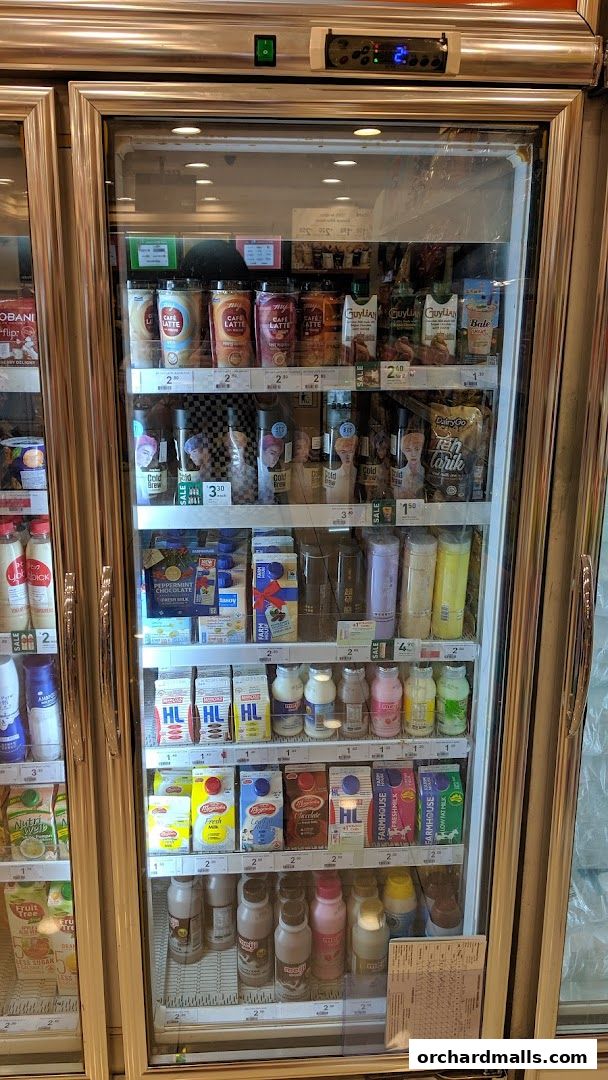 A refrigerated display case filled with various beverages and dairy products at 7-Eleven.