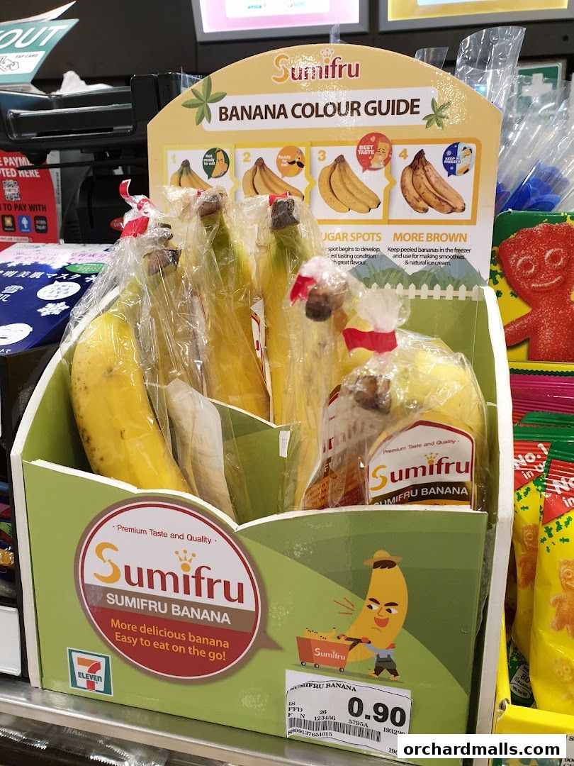A display of Sumifru bananas with a color guide and price tag at a 7-Eleven store.