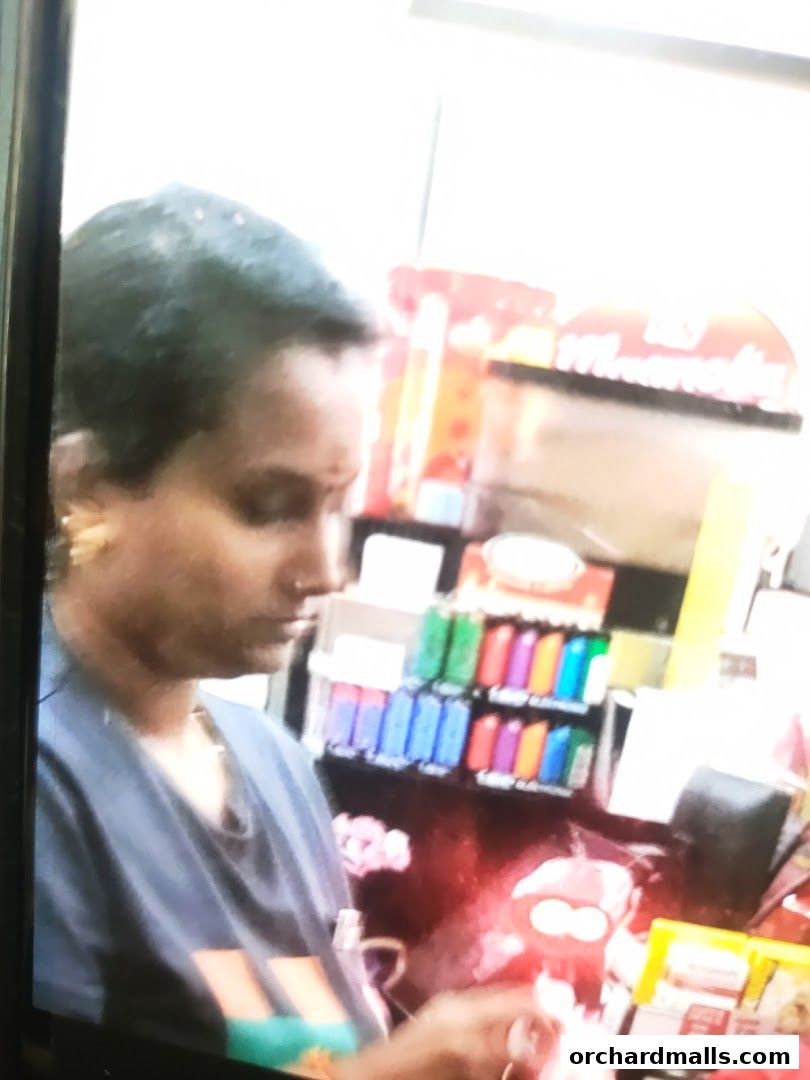 A woman stands at a checkout counter in a 7-Eleven store.