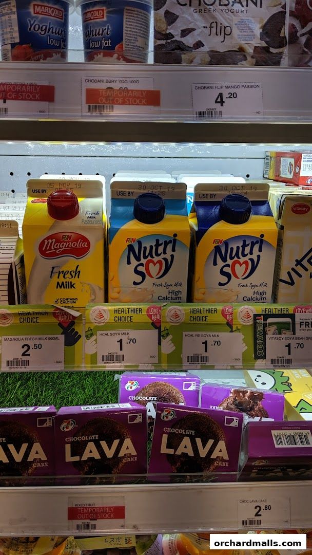 A refrigerated display case in a 7-Eleven store showcasing various milk, yogurt, and cake products.