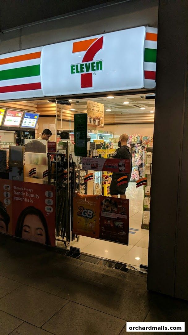 The exterior of a brightly lit 7-Eleven convenience store at night.