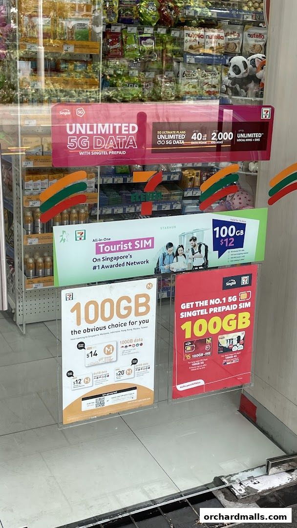 7-Eleven shop window displaying promotions for Singtel prepaid SIM cards and 5G data plans.