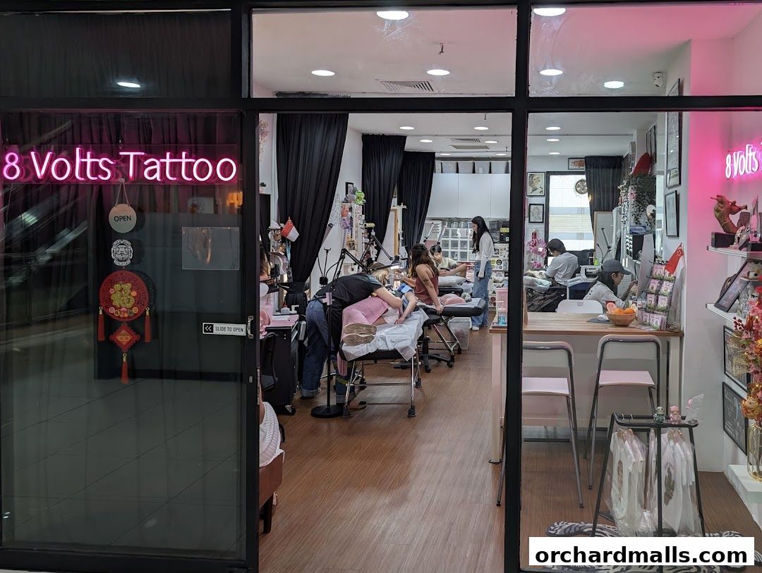Exterior view of 8 Volts Tattoo shop in Singapore, showing tattoo artists at work.