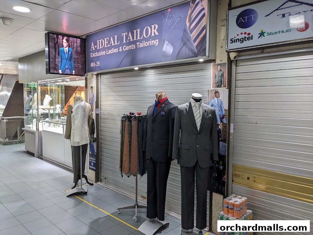 A-Ideal Tailor shop front with mannequins displaying suits and ties, and advertising screens.