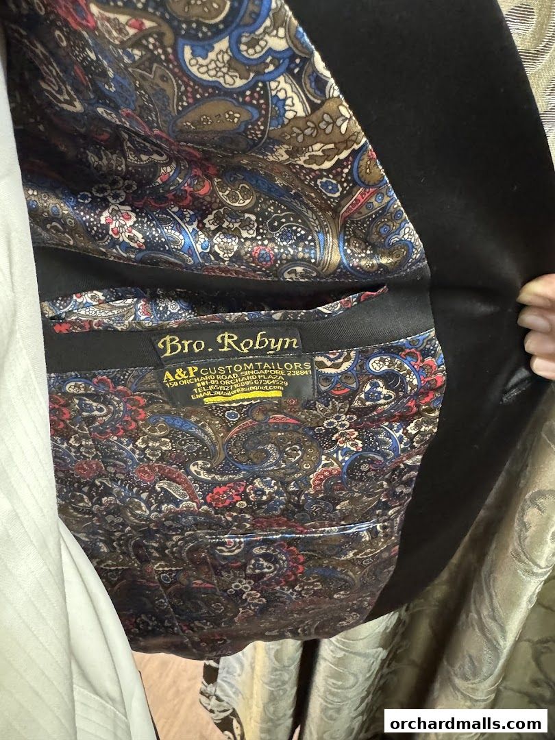 Close-up of a tailor's jacket lining with a paisley pattern and brand label.