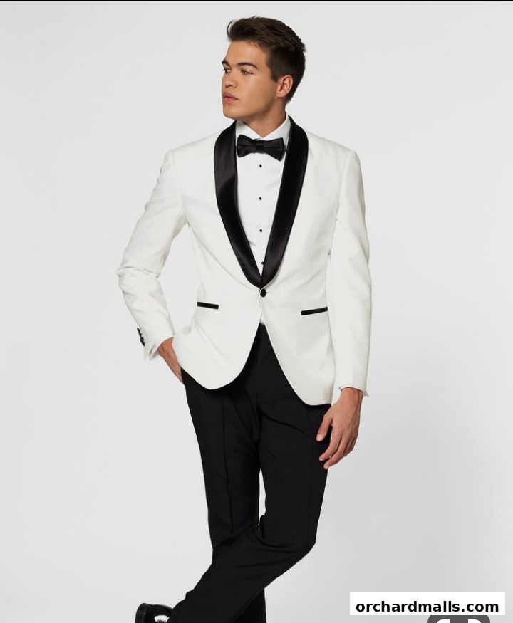 A man models a white tuxedo with black lapels and a black bow tie.