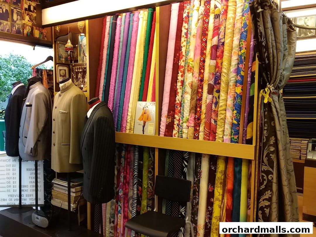A tailor shop interior displaying a wide selection of colorful fabrics and tailored suits on mannequins.