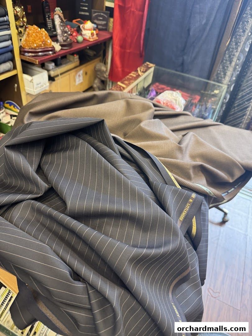 Close-up of pinstripe and striped fabric rolls at a tailor shop.