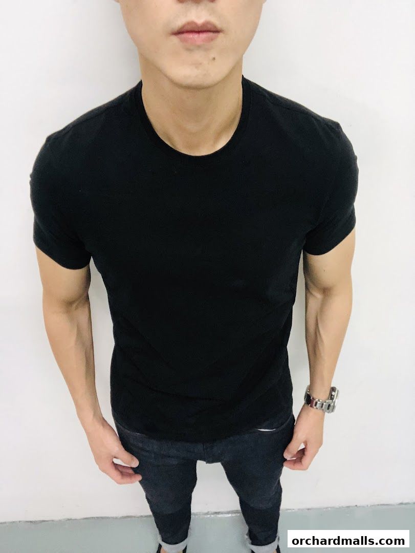 A man wearing a black t-shirt and dark jeans, showcasing casual style.