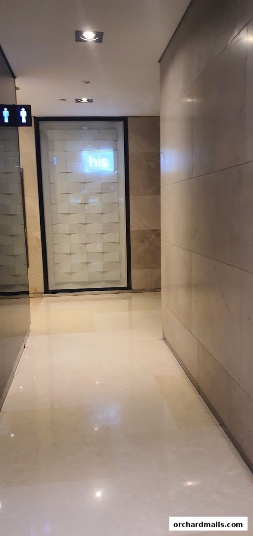 A hallway with a sign indicating 'his' and restroom symbols.