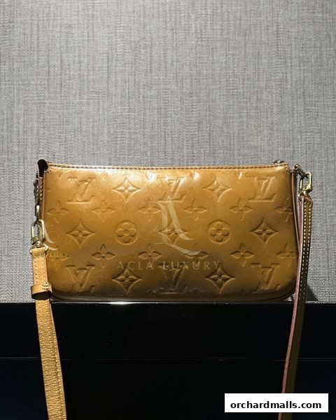 A close-up shot of a tan Louis Vuitton clutch bag with the signature monogram pattern.