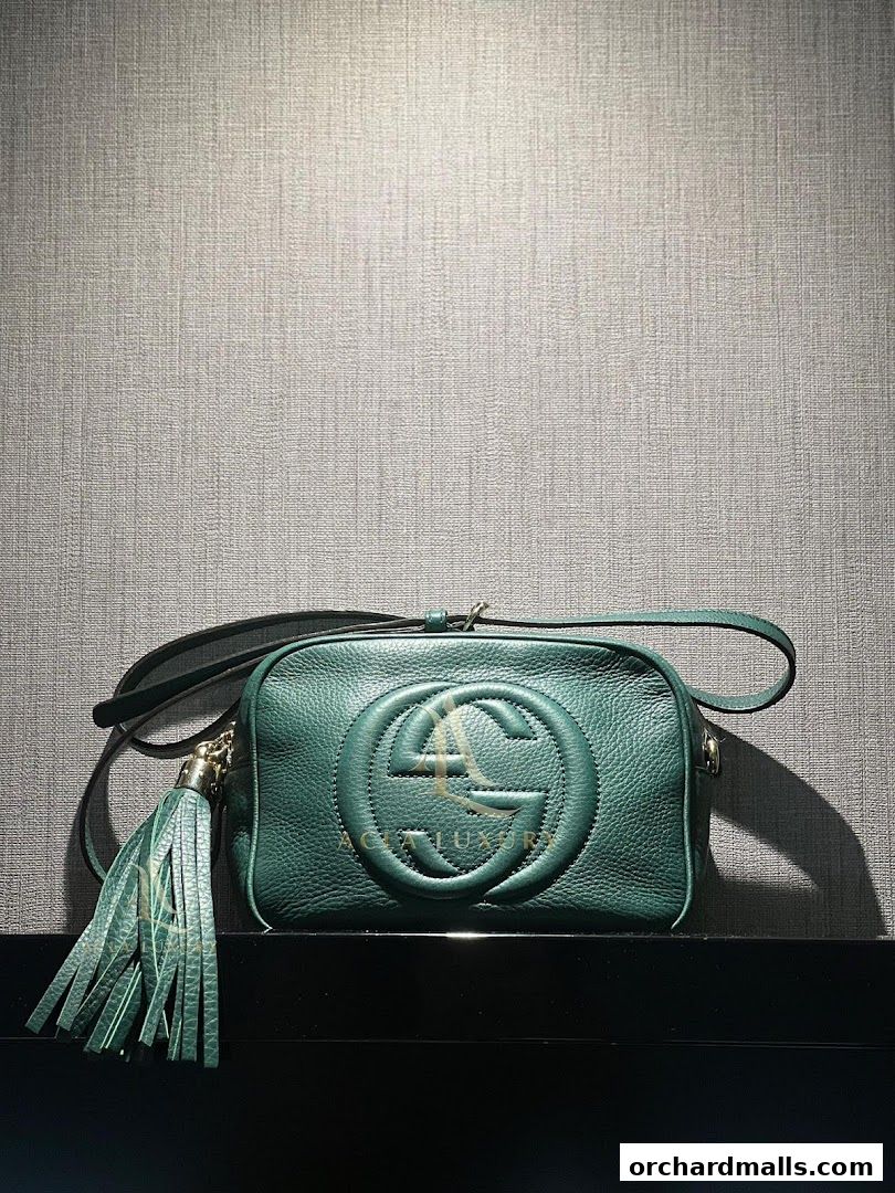 A green leather handbag with a tassel and embossed logo from Acla Luxury.
