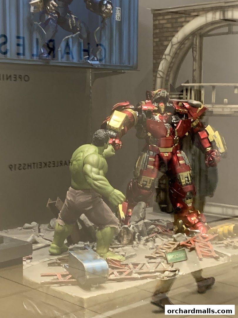 Hulk and Iron Man action figures in a battle diorama with debris and a Broadway sign.