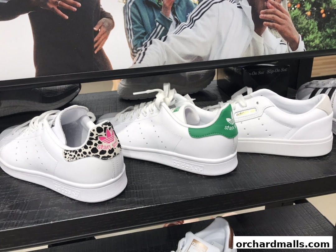 Close-up view of white Adidas sneakers with distinctive heel designs on display.