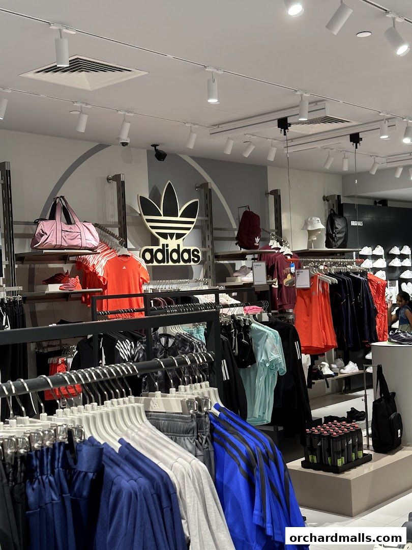 Interior of an Adidas store showcasing a wide variety of athletic apparel and accessories.