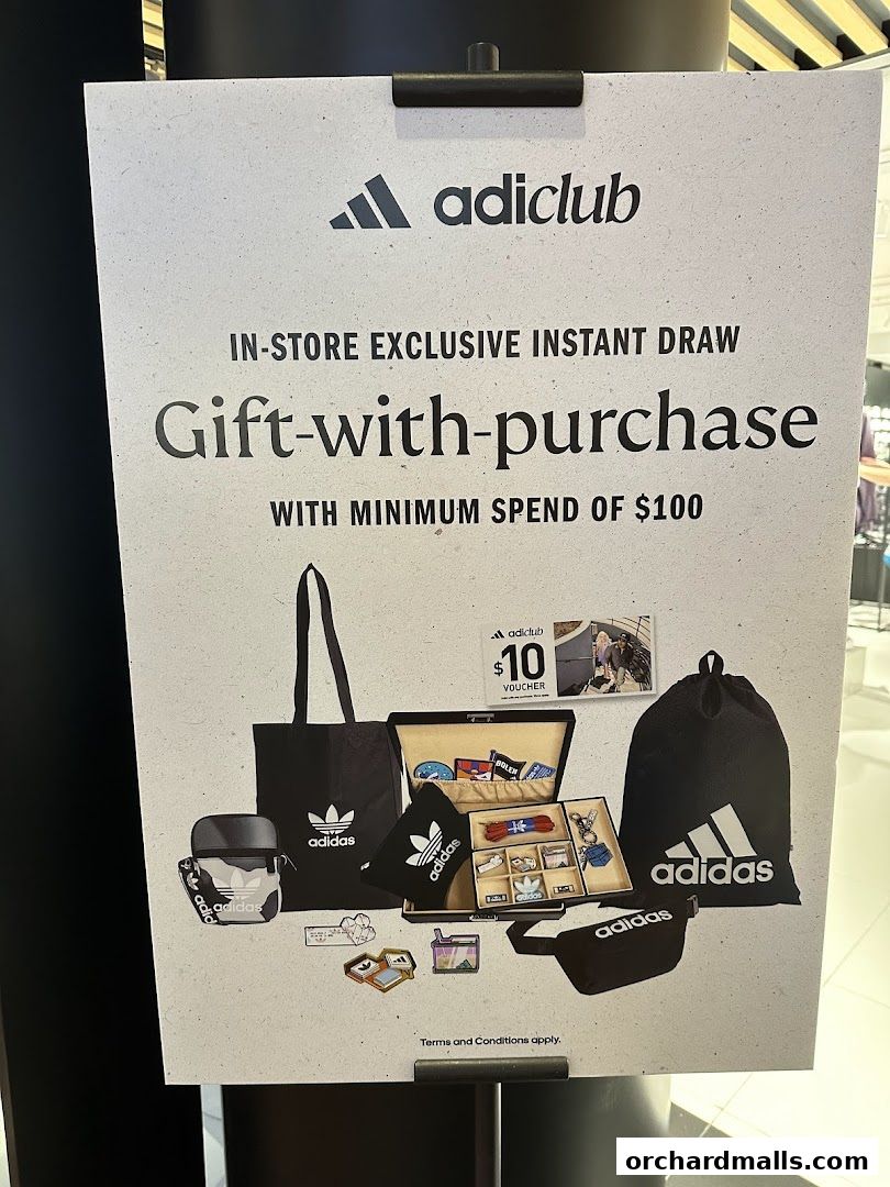 A sign advertising an Adidas gift-with-purchase promotion with a minimum spend.