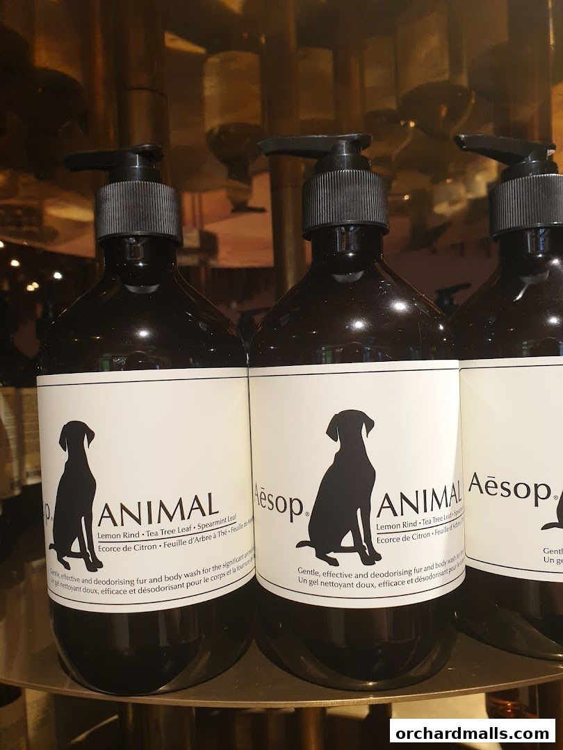 Close-up of Aesop Animal body wash bottles with black pumps and white labels featuring dog silhouettes.