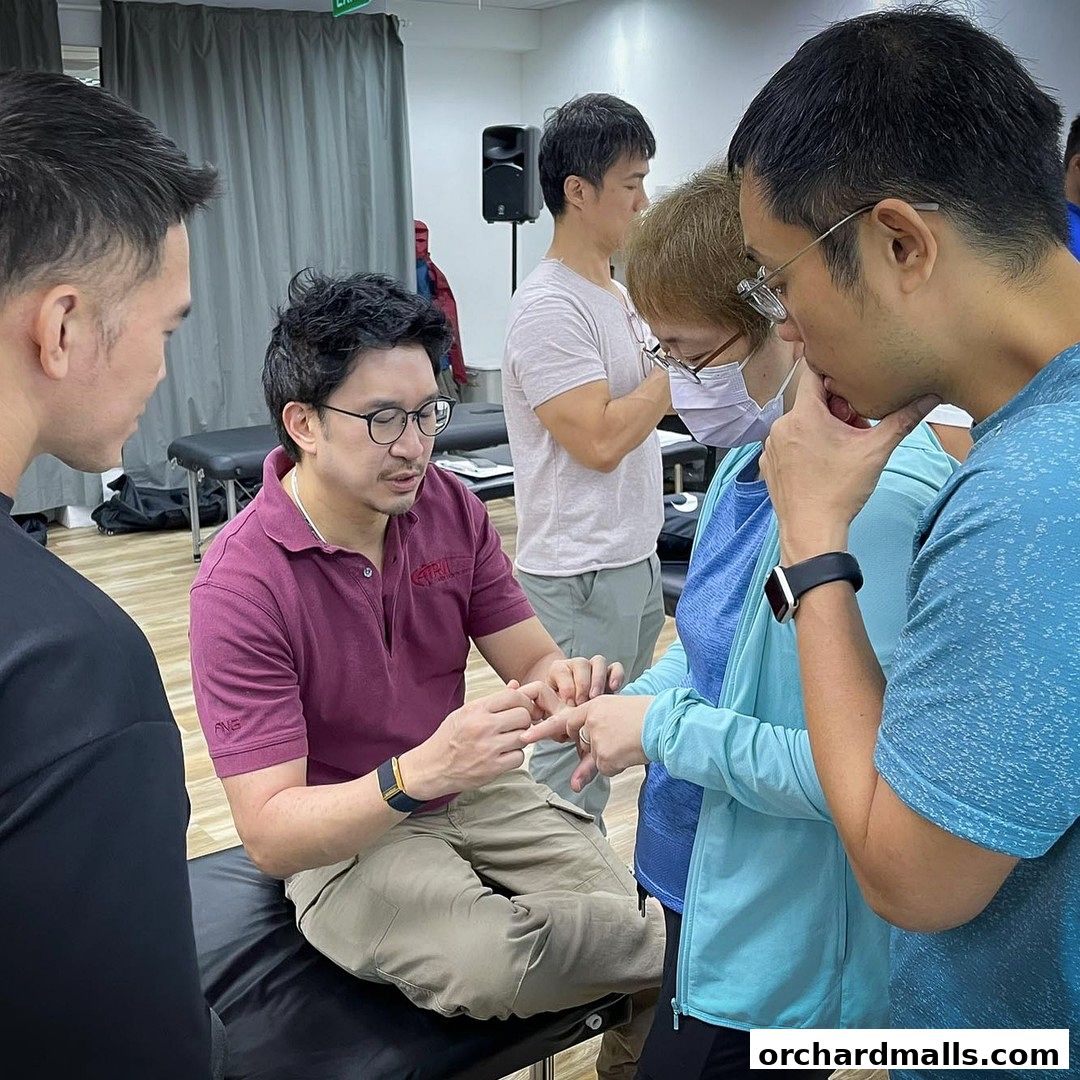 Chiropractor demonstrating a technique to a group of people in a clinic setting.