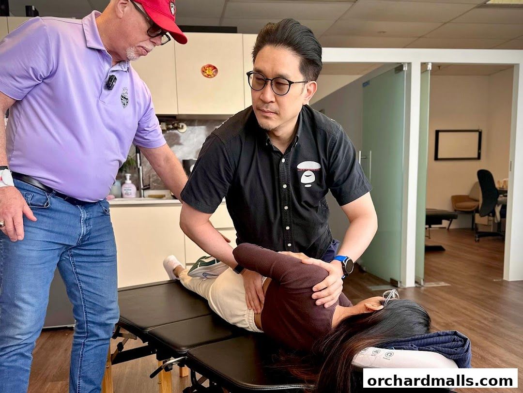 Chiropractors adjusting a patient on a treatment table in a clinic.