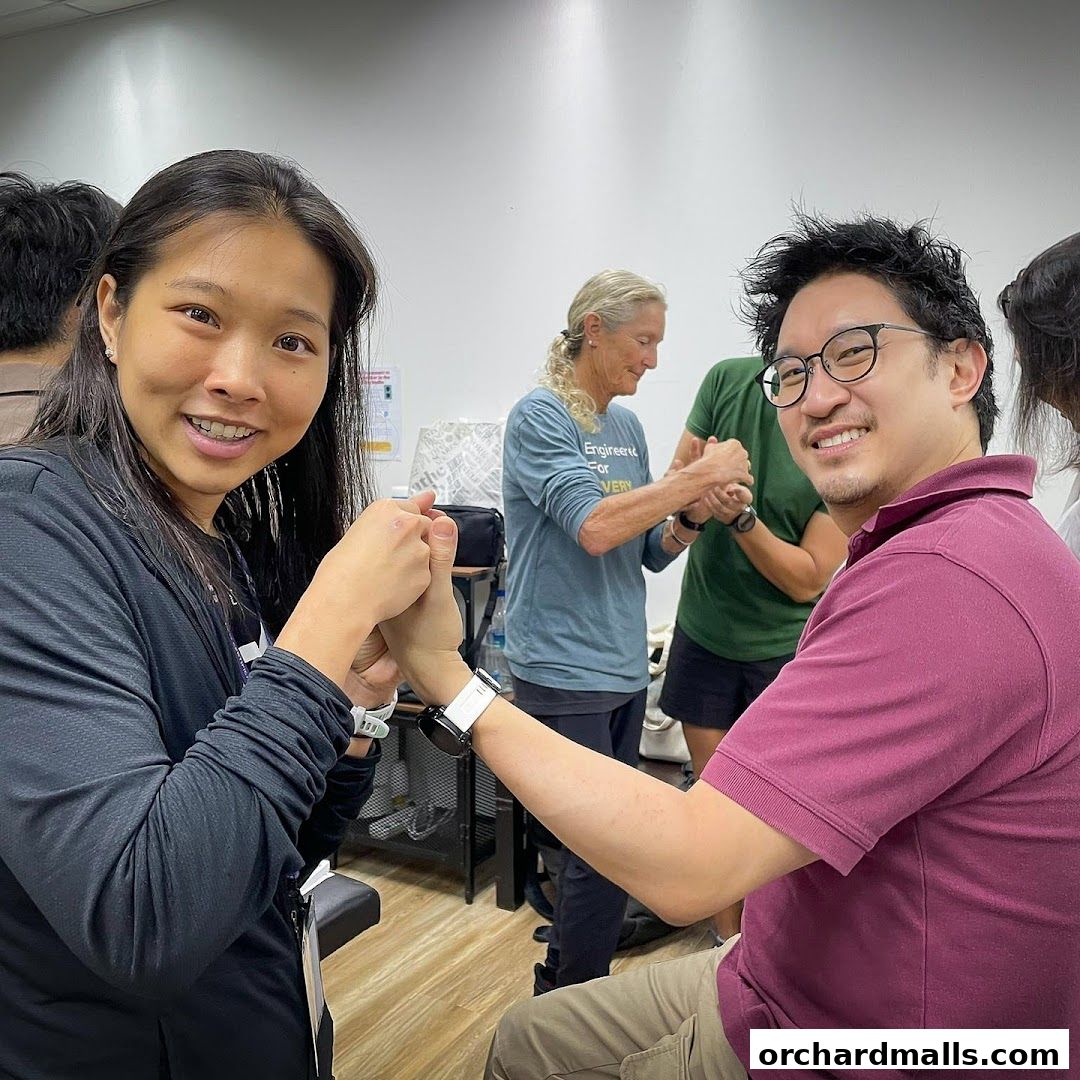 Chiropractic clinic staff and patients interacting, smiling and holding hands.