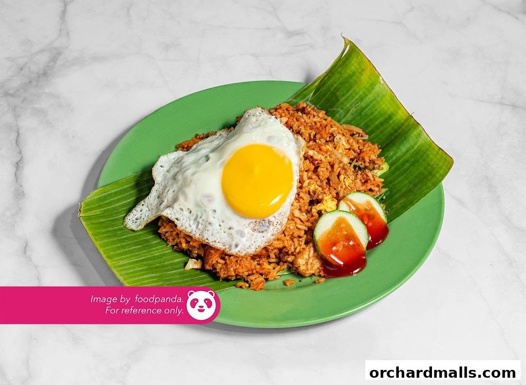 A plate of nasi goreng topped with a fried egg and cucumber slices.