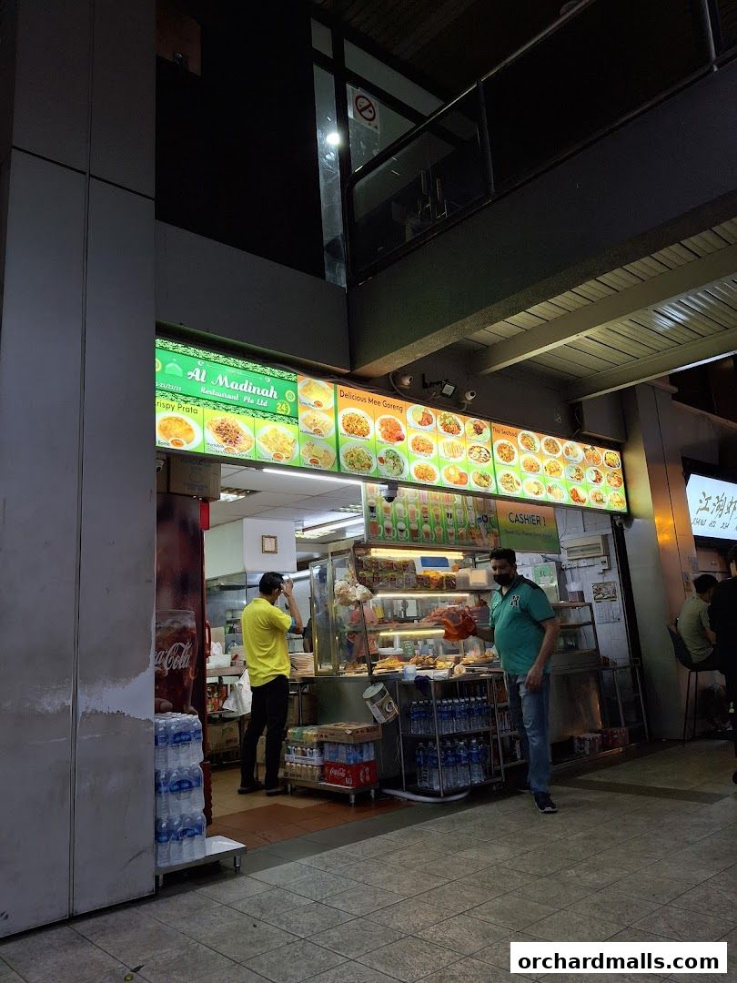 Al Madinah Restaurant exterior with a menu display and staff serving customers.