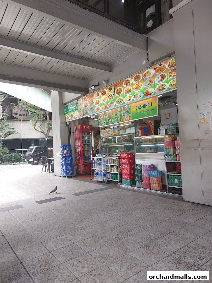 Al Madinah Restaurant storefront with a colorful menu board and various drinks displayed.