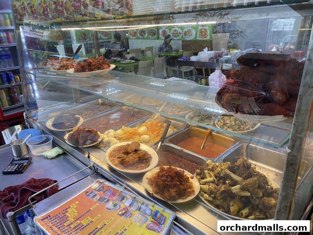 A display case filled with various dishes and a menu board at Al Madinah Restaurant.
