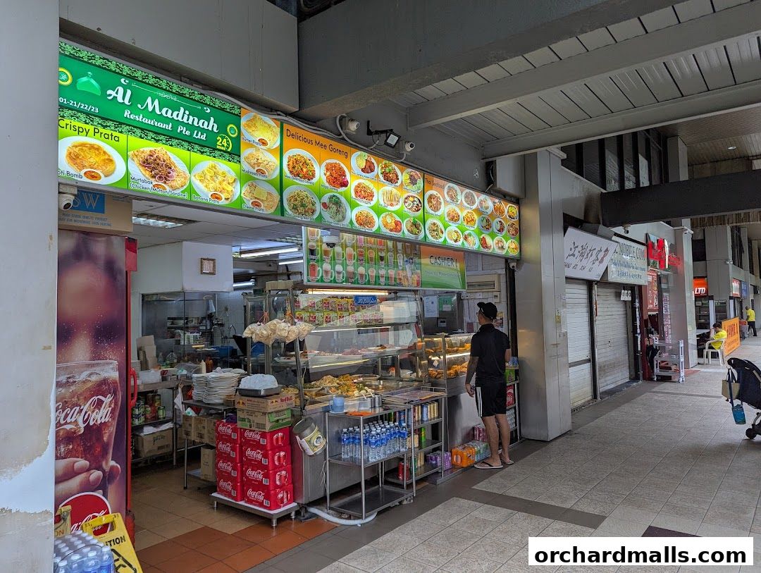 Al Madinah Restaurant storefront with a vibrant menu display and food offerings.