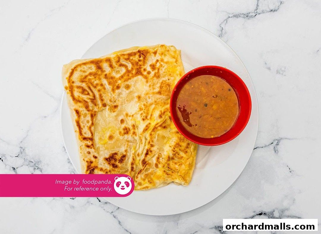 A close-up shot of a delicious Roti Canai with a side of curry sauce.