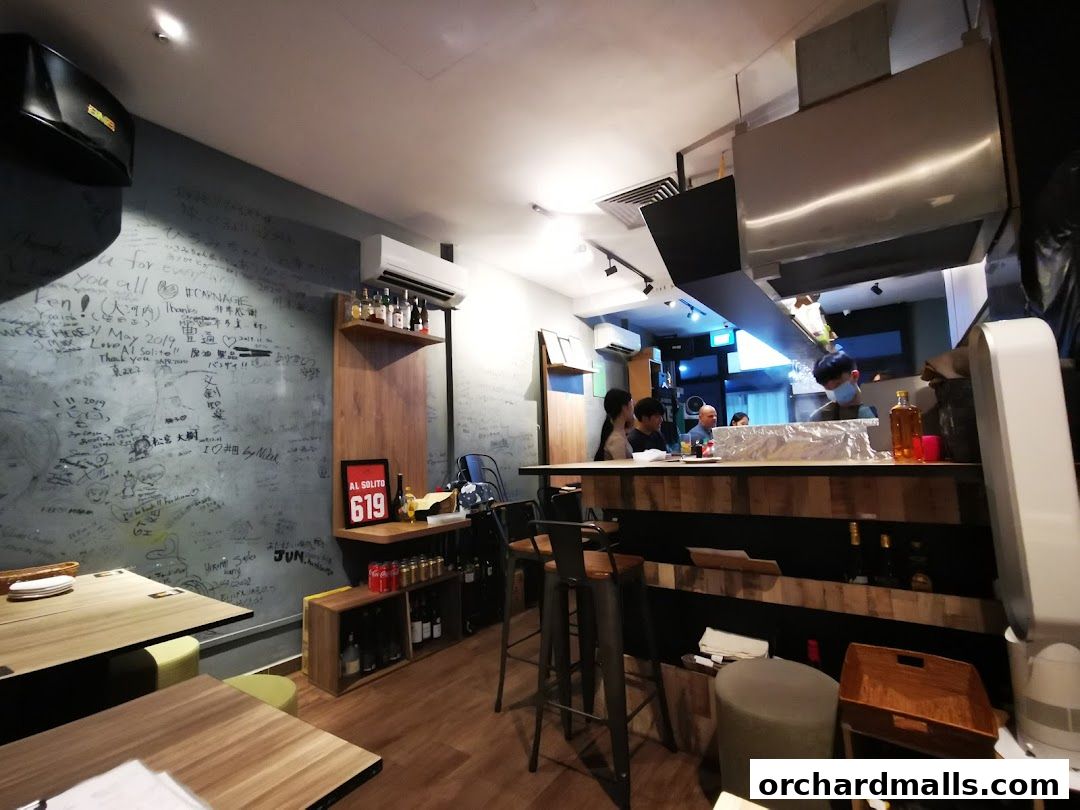 Interior of AL Solito Japanese Italian izakaya with graffiti-covered walls and a bar.