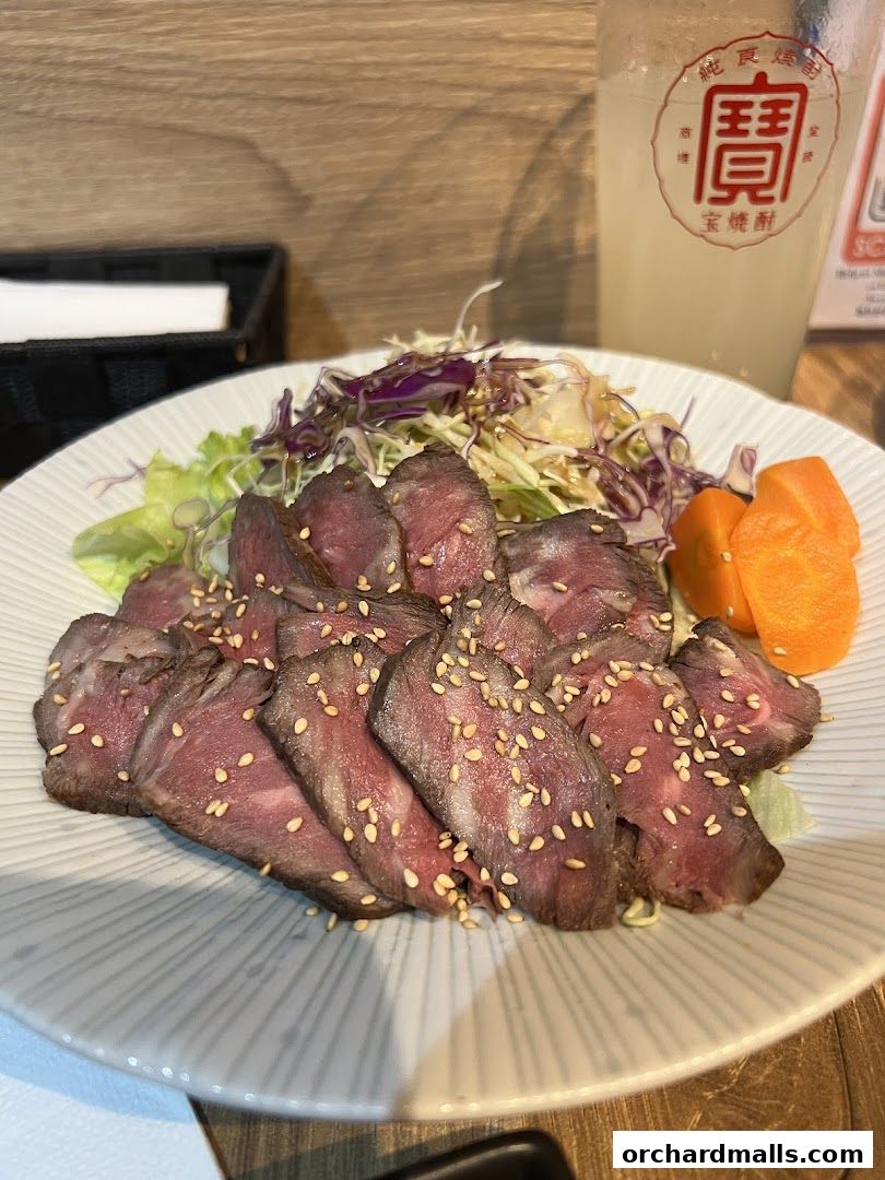 Thinly sliced roast beef salad with sesame seeds and a refreshing drink.