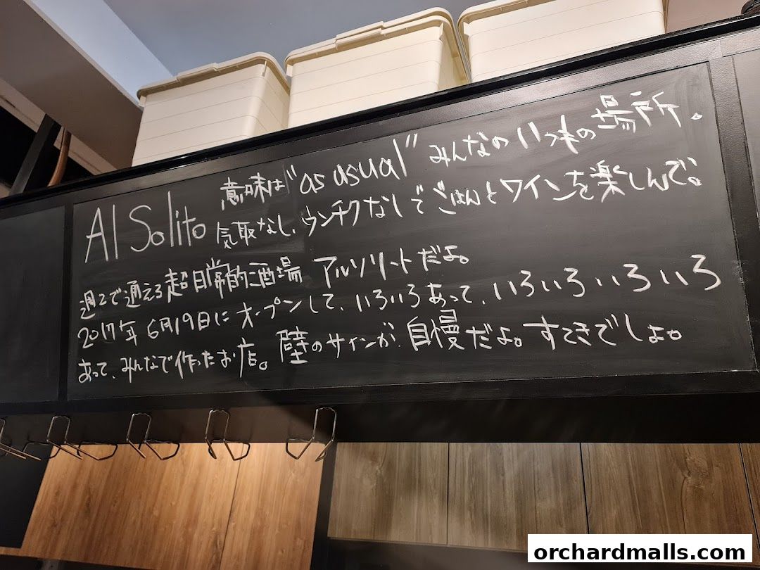 A blackboard sign inside AL Solito Japanese Italian izakaya with handwritten Japanese text.