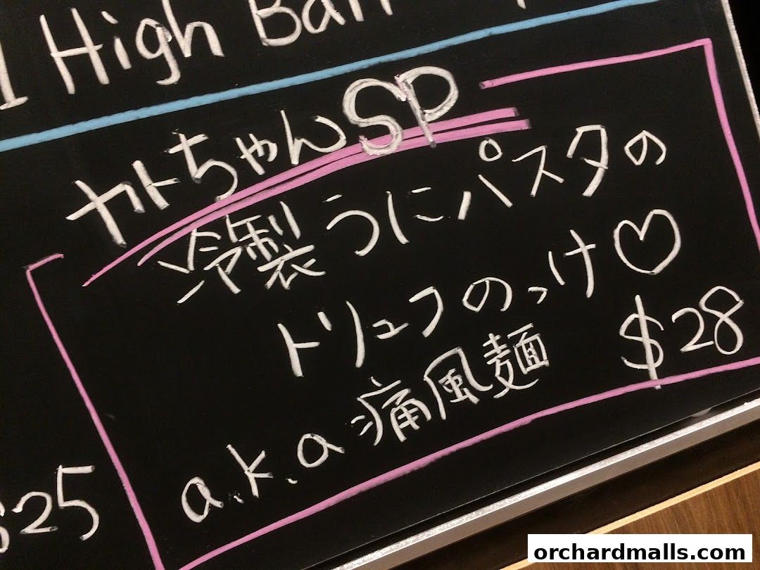 A chalkboard menu with Japanese and Italian dishes, including pasta and noodles.