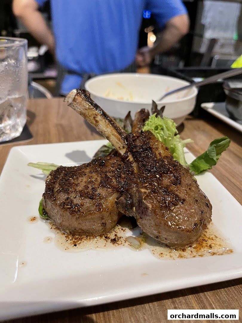 A plate of perfectly cooked lamb chops served with a side salad.