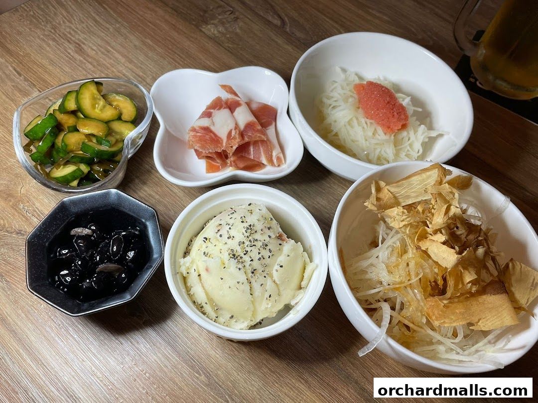A selection of small dishes including pickles, cured meat, mashed potatoes, and shredded vegetables.